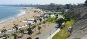 利马HOSPEDAJE TURISTICO CHORRILLOS Sueños de Luna INN的享有棕榈树海滩和大海的空中景致