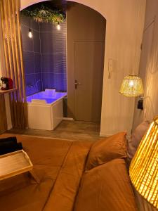 圣艾蒂安SUITE Serenity Room SPA- Balnéothérapie的带沙发和浴缸的客厅