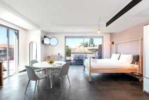 特拉维夫Jaffa Port TLV Hotel Apartments יפו תל אביב的卧室配有一张床和一张桌子及椅子