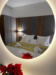 比哈奇Swiss Plus Hotel的镜子反射着卧室,卧室配有两张红色鲜花