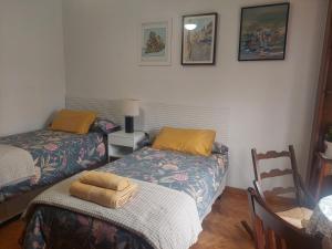 昆卡La Tioca的一间设有两张床、一张桌子和一把椅子的房间