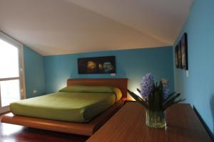 波蒂奇Villa Quaranta的一间卧室配有一张床和一张花瓶桌子