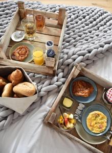 坎珀兰ZeeLand & Meer的早餐托盘,包括早餐食品和床上的饮料