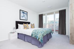 伦敦Large Canary Wharf 2 Bed Apartment with High Rise view的一间卧室设有一张大床和一个大窗户