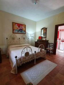 阿里特佐Agrifoglio B&B con giardino的卧室配有1张床、1张桌子和1把椅子
