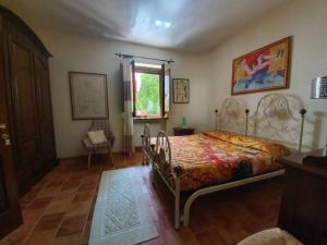 阿里特佐Agrifoglio B&B con giardino的卧室配有床、椅子和窗户。