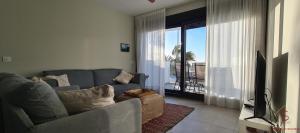 桑卢卡尔-德巴拉梅达Arenas de Doñana amplio apartamento frente del mar的客厅配有灰色的沙发和电视