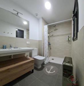 桑卢卡尔-德巴拉梅达Arenas de Doñana amplio apartamento frente del mar的一间带水槽、卫生间和淋浴的浴室
