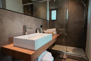 切法卢Insulae Resort的浴室配有白色水槽和淋浴。