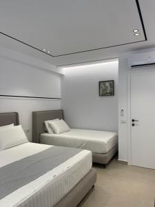 维利波吉Olivea Apartments的一间卧室设有两张床和天花板