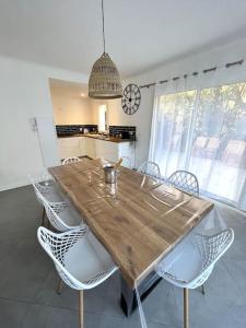 罗克布吕讷-卡普马丹Villa Victoria : Clim - Garage / 8 pers au Calme的厨房里配有一张木桌和椅子