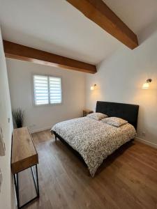 罗克布吕讷-卡普马丹Villa Victoria : Clim - Garage / 8 pers au Calme的一间卧室配有一张床、一张桌子和一个窗户。
