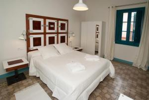 桑特费柳德吉克索尔斯Hotel Hostal Chic的一间卧室配有一张带白色床单的大床