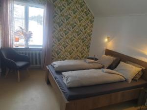 StrömsbrukBed & Breakfast de Jager的卧室配有床、椅子和窗户。