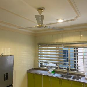 OgbojoEden Court Luxe的厨房配有吊扇和水槽