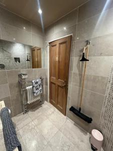 亚伦桥Airthrey Cottage的带淋浴的浴室和木门。