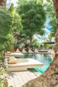 乌布Savanna Ubud的一个带躺椅和树木的游泳池