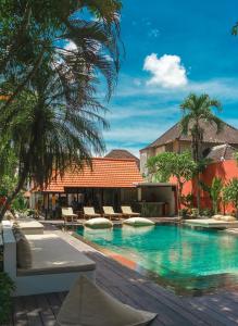 乌布Savanna Ubud的一个带椅子和棕榈树的度假游泳池