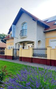豪伊杜纳纳什Sóvirág Termál Panzió的一座带围栏和紫色花卉的建筑