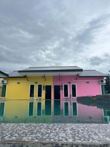 巴力文打D Sayang Homestay Parit Buntar MUSLIM SAHAJA的一座多彩的房子,前面有水