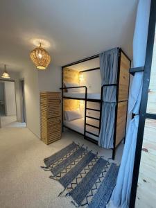 丹吉尔Socco Hostel的一间带双层床的卧室和一间带地毯的房间