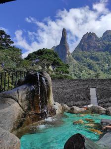 瓜皮米林Casa 2 qtos, sendo suíte com cama Queen ar condicionado的瀑布,位于一个山池中,背景是