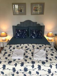 AzasVilla Toscane - Atelier d'Artistes et B&B à 20 mn de Toulouse的一张带蓝色和白色床单及枕头的床