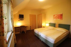 ZwentendorfRosenhotel - Serviced Apartments的配有一张床和一张书桌的酒店客房