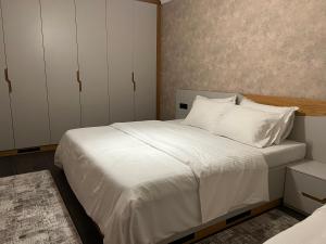Apartament Koha的一间卧室配有带白色床单和枕头的床。