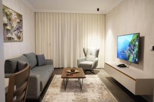 Apartament Koha的客厅配有沙发、椅子和电视