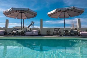尼亚·蒙达尼亚Berries Luxury Apartments的一个带椅子和遮阳伞的游泳池