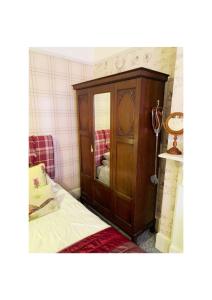 南安普敦The Old Merchants House - The Highlands Room的卧室配有木制橱柜,位于床边