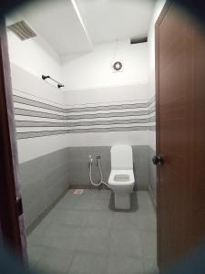 PayyannūrComfort INN的浴室设有卫生间,墙上有条纹