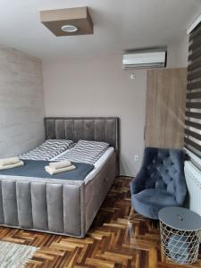 巴尼亚科维利亚查Apartman Ristanovic的一间卧室配有一张床和一张蓝色椅子