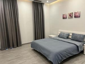 阿尔科兰Sama Chalet kuwait的一间卧室配有一张带灰色床单的大床