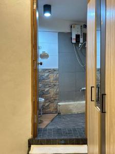 曼谷Chubby 5 Room 5的带淋浴的浴室以及带玻璃门的卫生间。