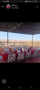 TagouniteSAHARA EXPERTISE的一间设有桌椅的餐厅,享有沙漠美景