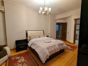 开罗Duplex by Aqua Maadi Degla Group 5 stars的一间卧室配有一张大床和一个吊灯。
