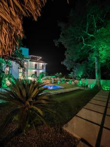 佩达西镇Hotel Pedasí Nature Paradise的一座带花园的夜晚绿灯房子