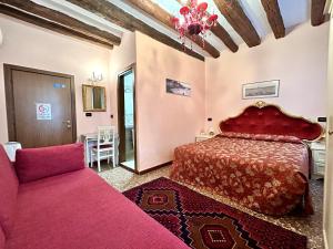 威尼斯阿罗吉塞丽娜酒店的一间卧室配有红色的床和一张沙发