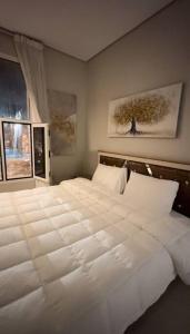 吉赞كوخ الشاطئ جمال الحاضر والطبيعة的卧室内的一张大白色床,带有窗户