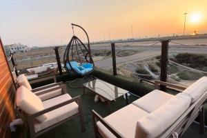 吉赞كوخ الشاطئ جمال الحاضر والطبيعة的阳台设有带椅子的门廊和秋千