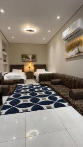 吉赞كوخ الشاطئ جمال الحاضر والطبيعة的一间设有两张床的房间和蓝白色地毯