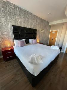 卡迪夫加的夫皇家酒店的一间卧室配有一张大床和黑色床头板