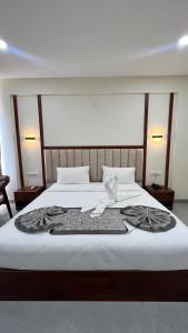 班加罗尔Vrishi Inn的一间卧室配有一张床,床上有毛巾