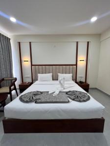 班加罗尔Vrishi Inn的酒店客房,配有带毛巾的床
