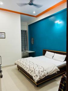 KhātuPrem Bhawan Guest House的一间卧室配有一张蓝色墙壁的床
