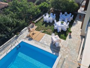 特尔斐Hotel Apollonia的一个带桌椅的后院和一个游泳池