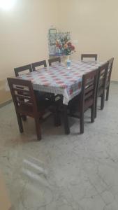 比纳里姆D 'SOUZA HOLIDAY HOME的一张桌子,上面有四把椅子和一张桌子,上面有被子