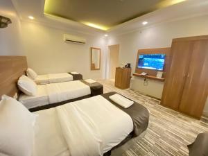 麦加فندق زهرة الياسر مكة的酒店客房设有两张床和一台平面电视。